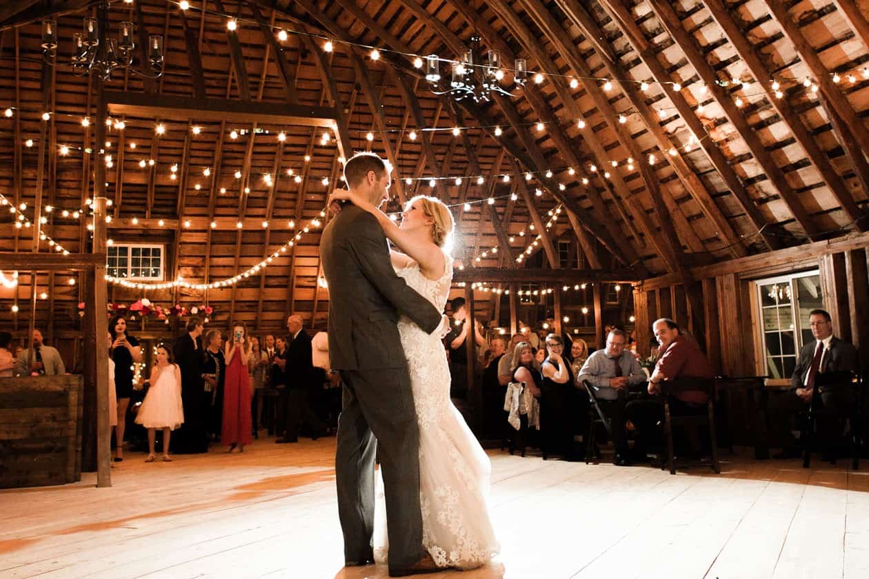Elegant barn wedding dance with string lights and rustic charm.