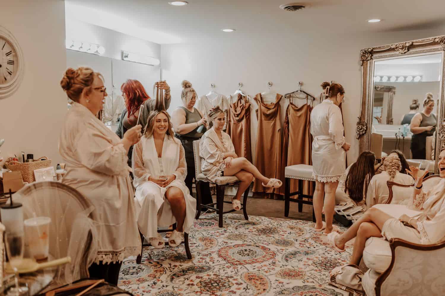 Bridal party getting ready in a cozy, stylish room with dresses and accessories.
