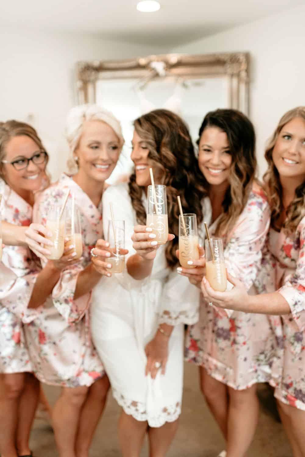Bridesmaids and bride celebrating with drinks at Dellwood Barn wedding venue.