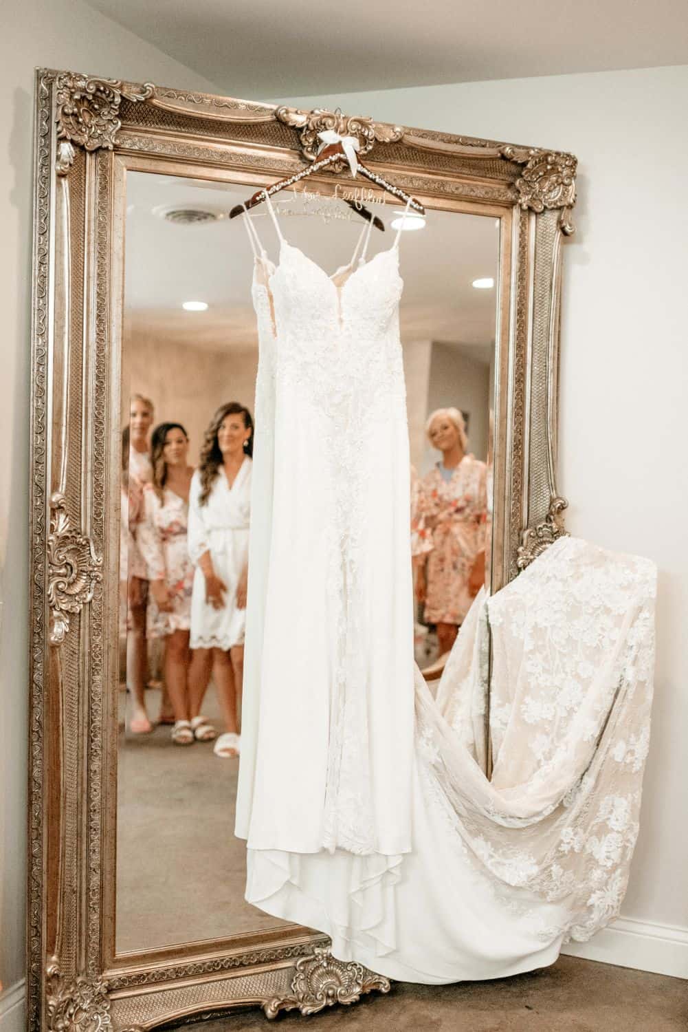 Wedding dress displayed on ornate mirror at Dellwood Barn Weddings.