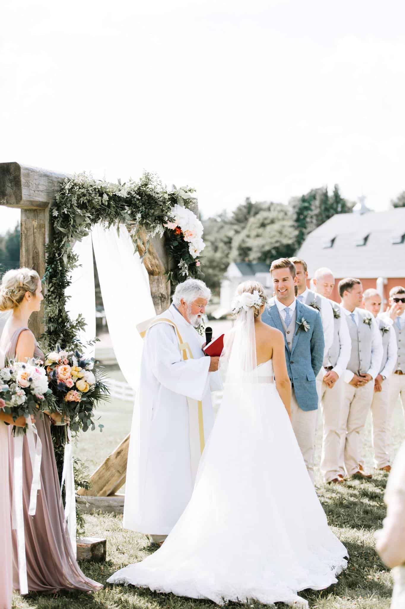 Wedding ceremony at Dellwood Barn with bride, groom, and wedding party.