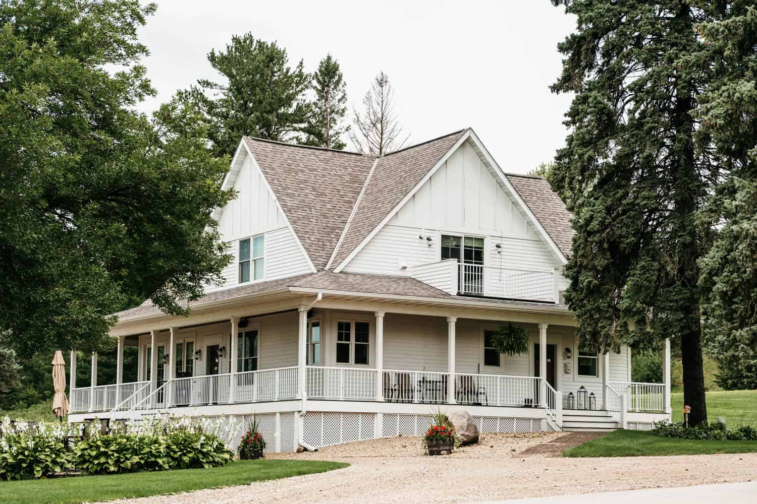 White barn wedding venue with spacious porch and scenic surroundings.