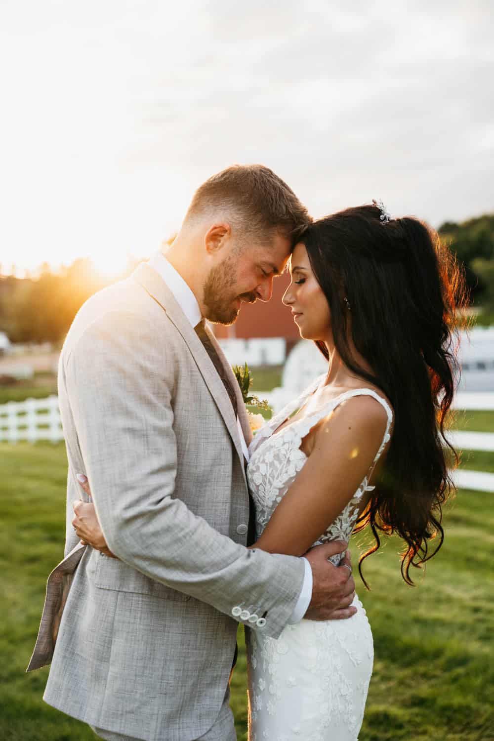 Romantic barn wedding with bride and groom embracing outdoors.