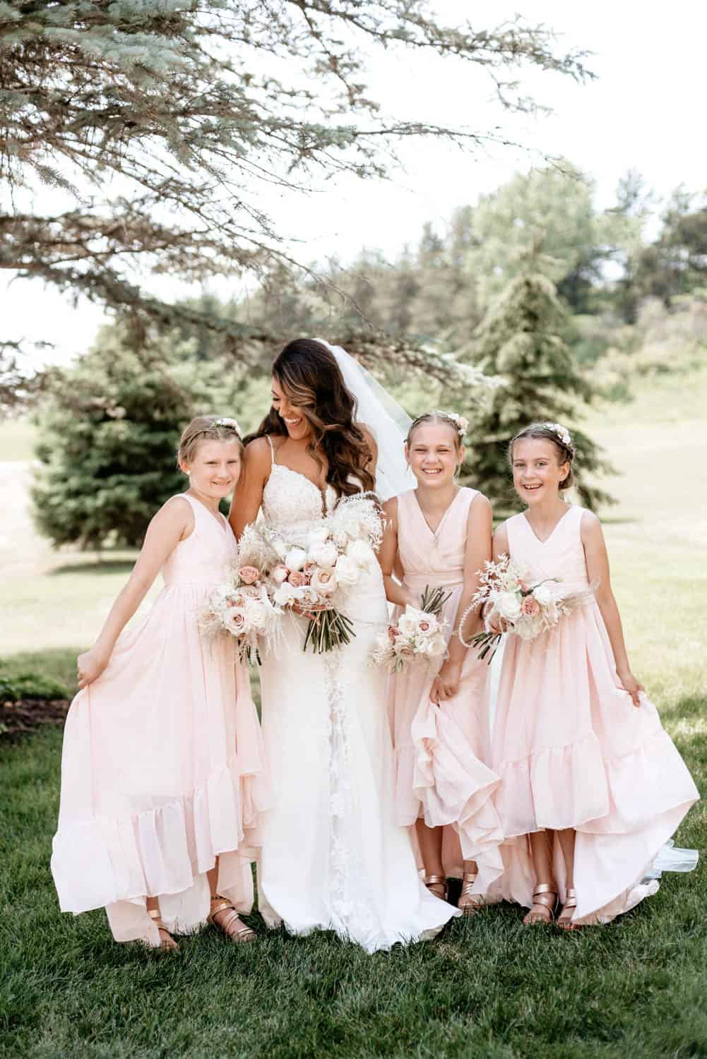 Bridesmaids and bride celebrating outdoors at Dellwood Barn wedding venue.