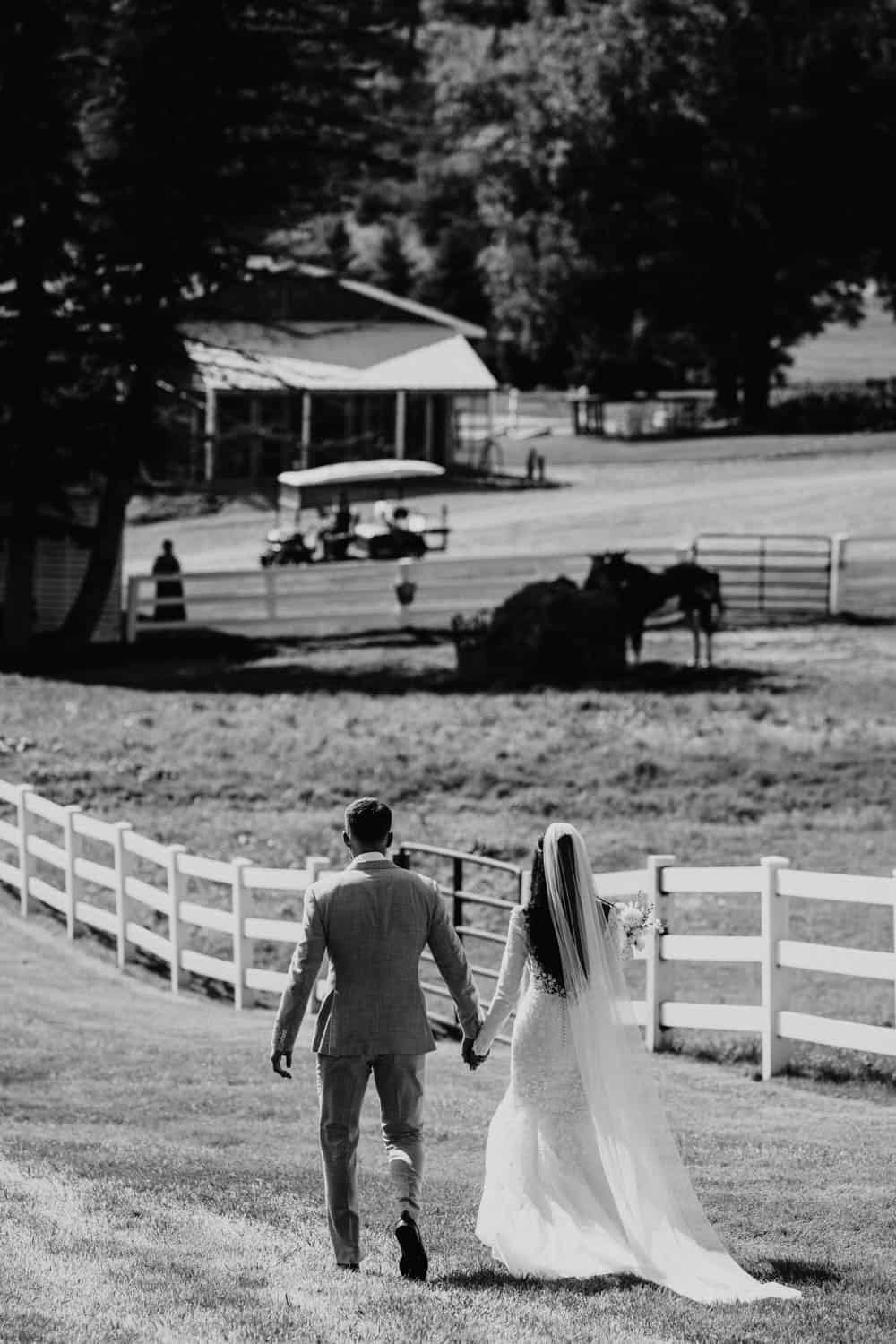 Bride and groom walking hand in hand at Dellwood Barn wedding venue.