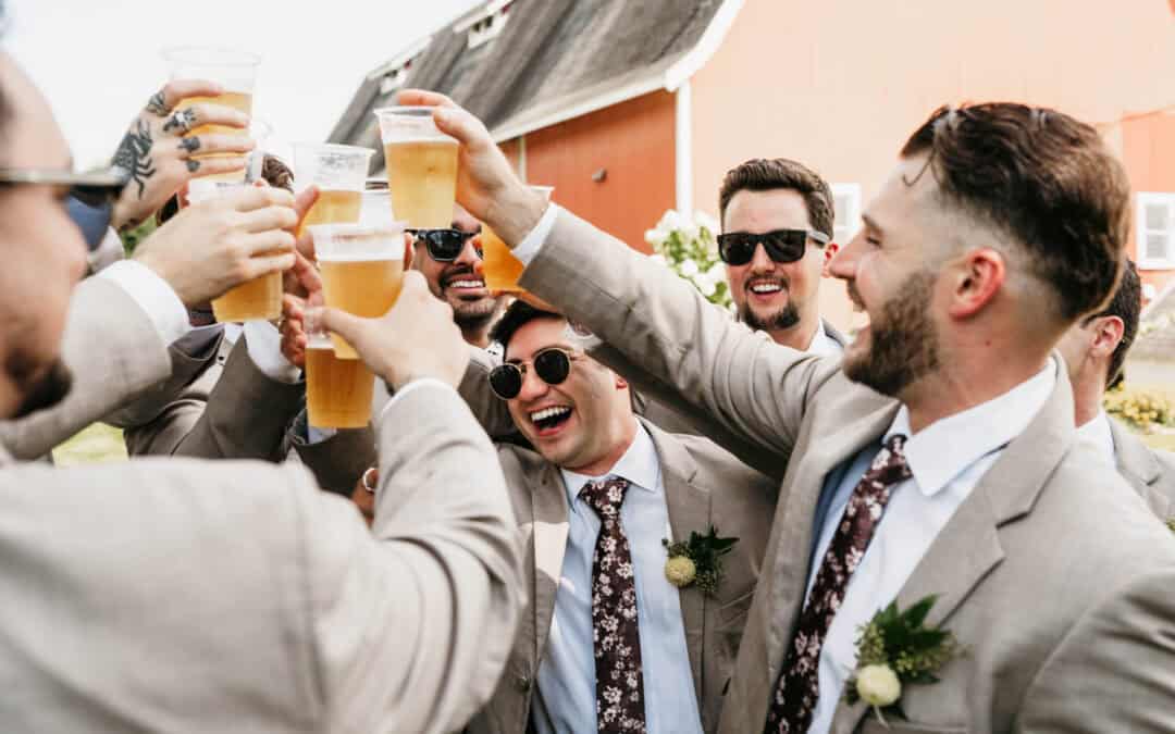 Wedding guests raising glasses in toast at Dellwood Barn wedding venue.