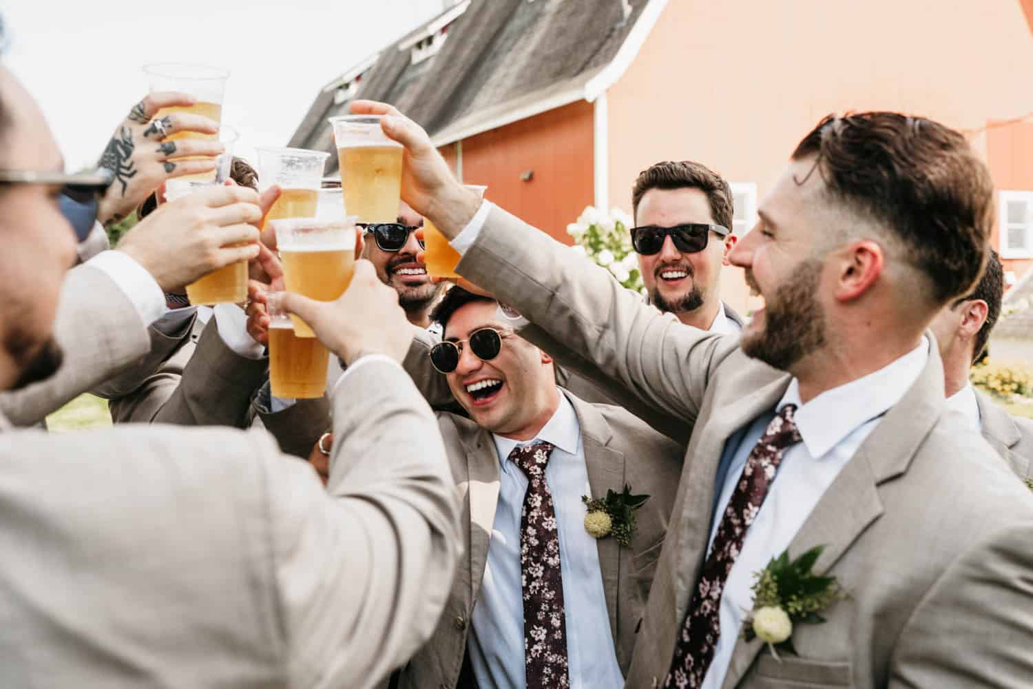 Wedding guests raising glasses in toast at Dellwood Barn wedding venue.